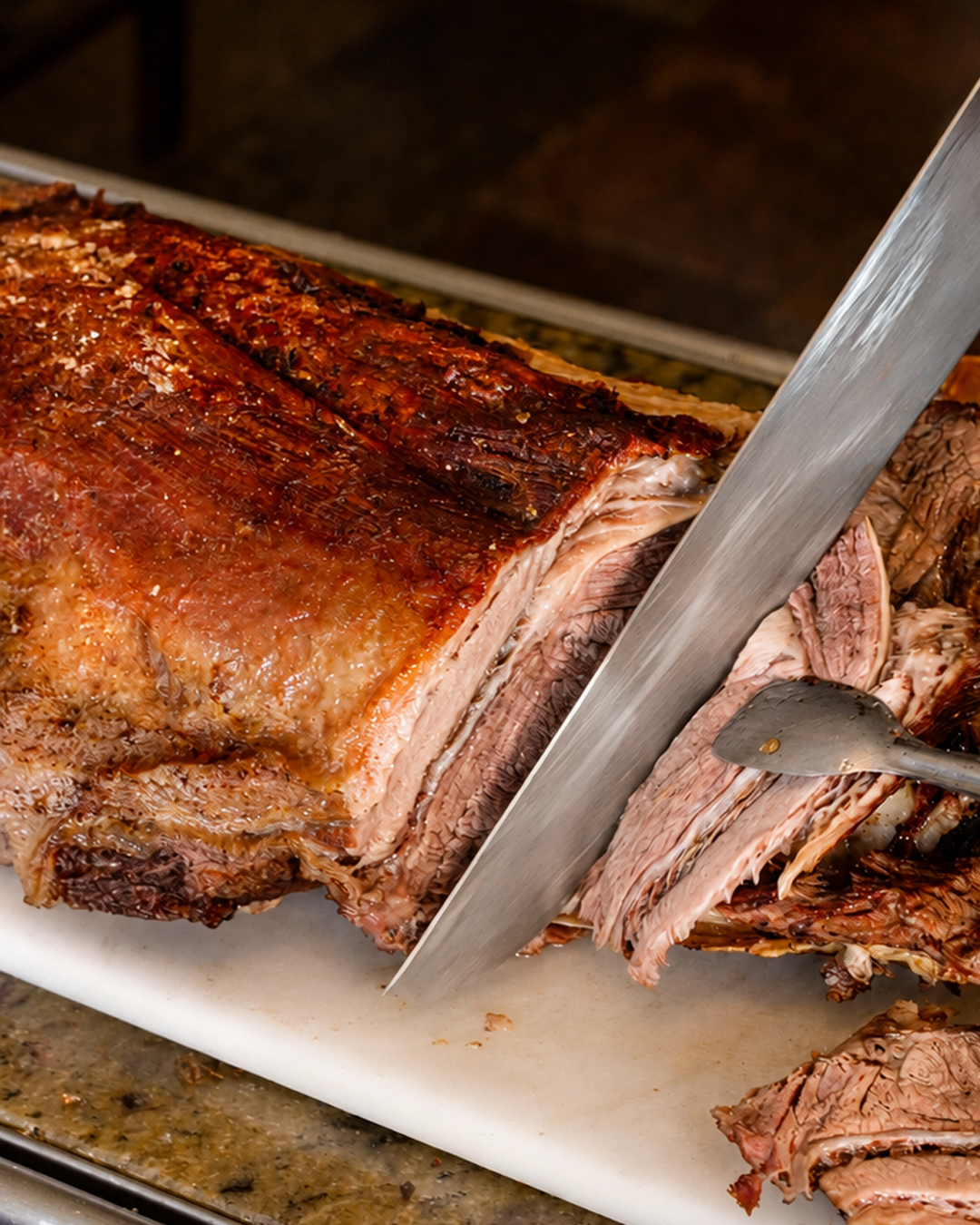 Peça de carne assada sendo fatiada
